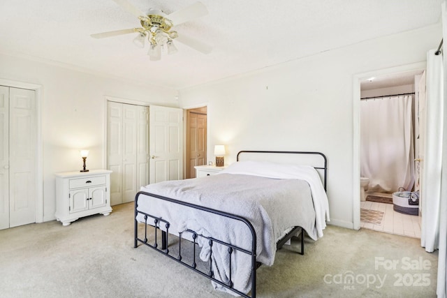 334 Lakeview Cir, Lugoff, SC 29078 - bedroom featuring light colored carpet, multiple closets, ensuite bathroom, and a ceiling fan