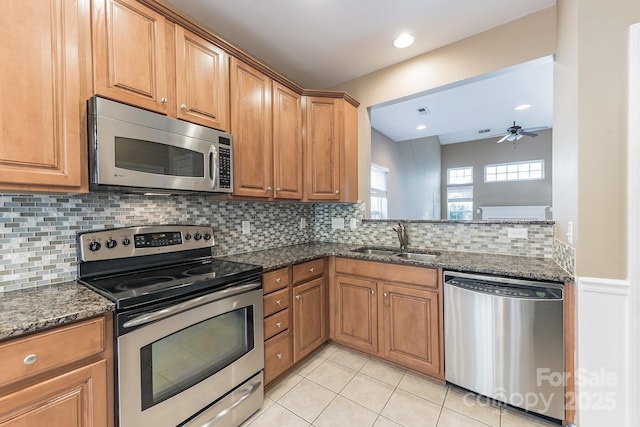 165 N Arcadian Way, Mooresville, NC 28117 - kitchen with stainless steel appliances, a sink, light tile patterned floors, decorative backsplash, and dark stone countertops