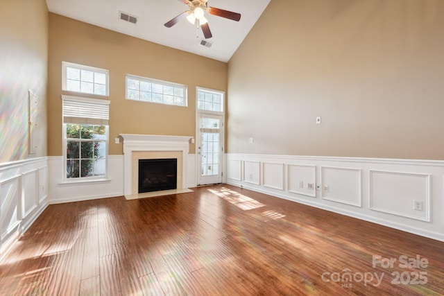 165 N Arcadian Way, Mooresville, NC 28117 - unfurnished living room with high vaulted ceiling, a ceiling fan, a wainscoted wall, a fireplace with flush hearth, and wood finished floors