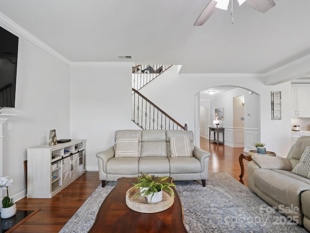 2178 Stone Pile Dr SW, Concord, NC 28025 - living room featuring arched walkways, ornamental molding, wood finished floors, a ceiling fan, and stairway