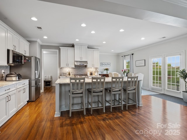 2178 Stone Pile Dr SW, Concord, NC 28025 - kitchen featuring stainless steel appliances, crown molding, dark wood-type flooring, a center island with sink, and backsplash