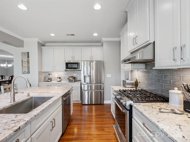 2178 Stone Pile Dr SW, Concord, NC 28025 - kitchen with appliances with stainless steel finishes, a sink, under cabinet range hood, crown molding, and backsplash