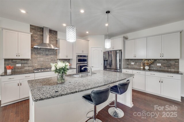 1033 Dorsey Dr, Fort Mill, SC 29715 - kitchen featuring stainless steel appliances, wall chimney exhaust hood, a sink, decorative backsplash, and a center island with sink