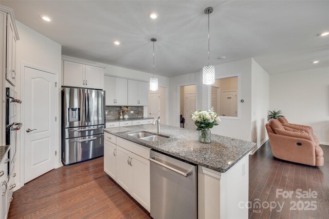1033 Dorsey Dr, Fort Mill, SC 29715 - kitchen featuring stainless steel appliances, a sink, dark wood-style floors, a center island with sink, and stone counters
