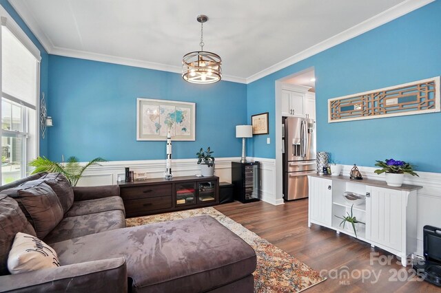 1437 Imperial Ct, York, SC 29745 - living room featuring dark wood finished floors, a chandelier, a wainscoted wall, and crown molding