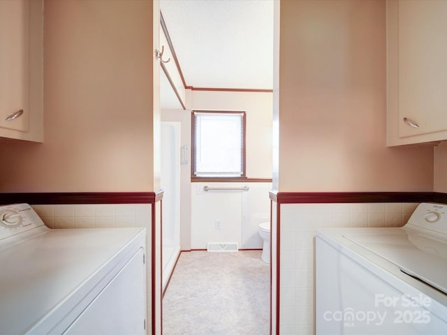 1155 Hasty Rd, Peachland, NC 28133 - washroom featuring independent washer and dryer, tile walls, cabinet space, and wainscoting