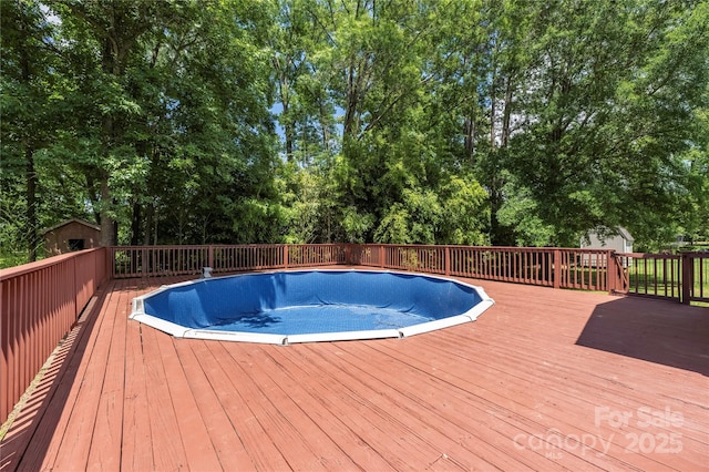 6504 Sybil Ct, Indian Trail, NC 28079 - view of pool with a wooden deck, an empty pool, and view of wooded area