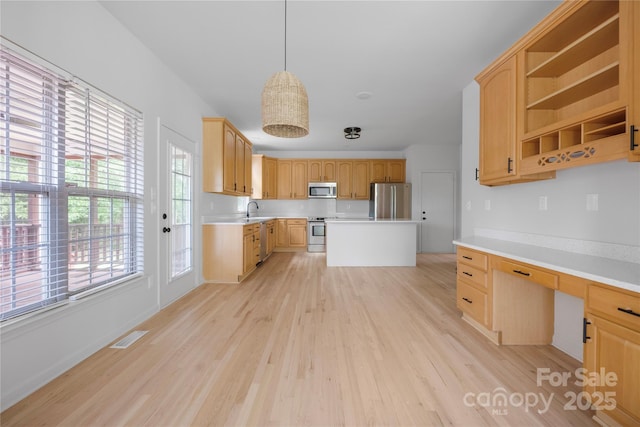 6504 Sybil Ct, Indian Trail, NC 28079 - kitchen with appliances with stainless steel finishes, light wood finished floors, a sink, light countertops, and light brown cabinetry