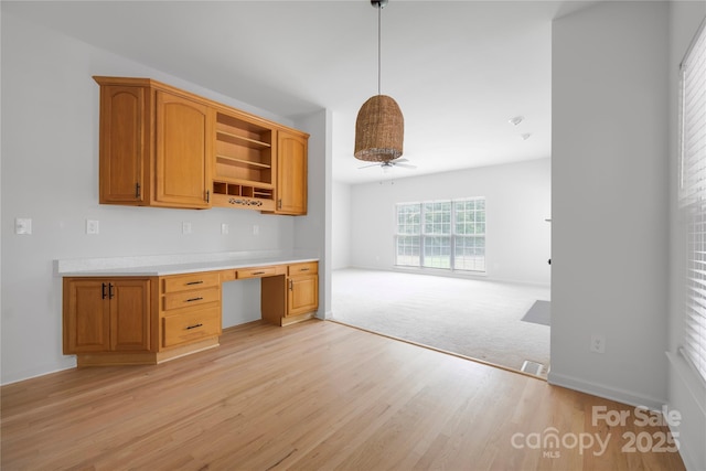 6504 Sybil Ct, Indian Trail, NC 28079 - kitchen featuring open shelves, light wood-style flooring, light countertops, hanging light fixtures, and open floor plan