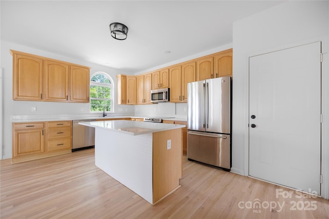 6504 Sybil Ct, Indian Trail, NC 28079 - kitchen with appliances with stainless steel finishes, light wood-type flooring, light brown cabinets, light countertops, and a kitchen island