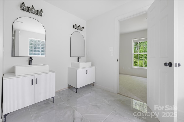 6504 Sybil Ct, Indian Trail, NC 28079 - bathroom featuring two vanities, marble finish flooring, and baseboards
