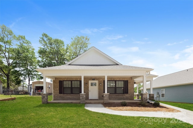 view of front facade with brick siding, a porch, and a front lawn