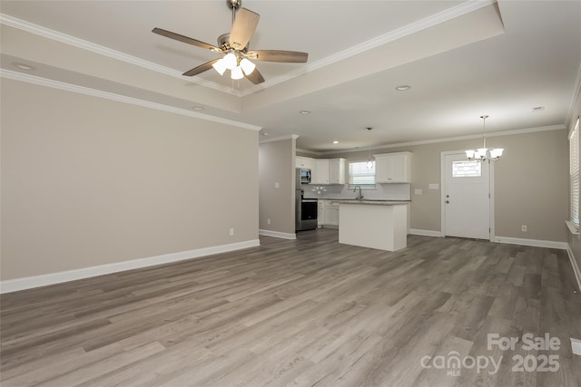 unfurnished living room featuring a chandelier, wood finished floors, a ceiling fan, baseboards, and recessed lighting