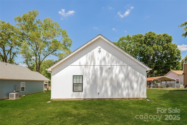 view of side of property featuring a carport, a lawn, and central AC