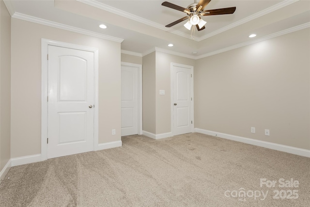 unfurnished bedroom featuring recessed lighting, carpet floors, crown molding, baseboards, and a tray ceiling