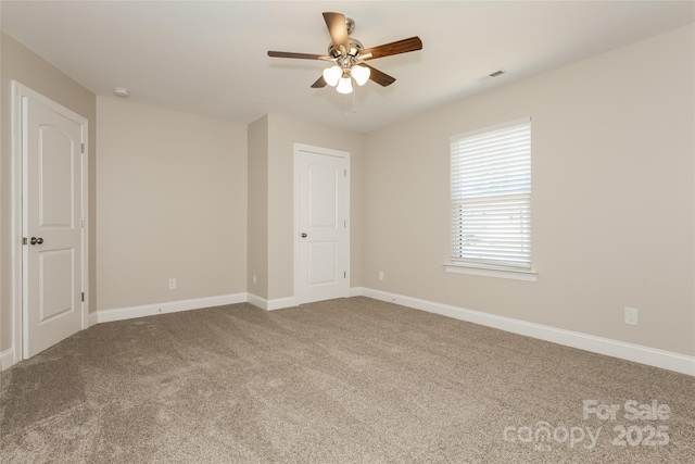 unfurnished room with carpet floors, ceiling fan, baseboards, and a smoke detector