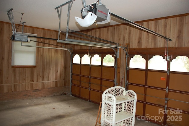garage featuring a garage door opener and wood walls