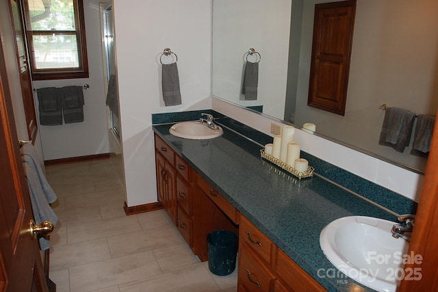full bathroom featuring double vanity, tile patterned floors, and baseboards