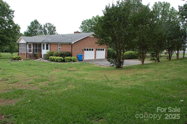 ranch-style house with brick siding, a garage, a front lawn, and concrete driveway
