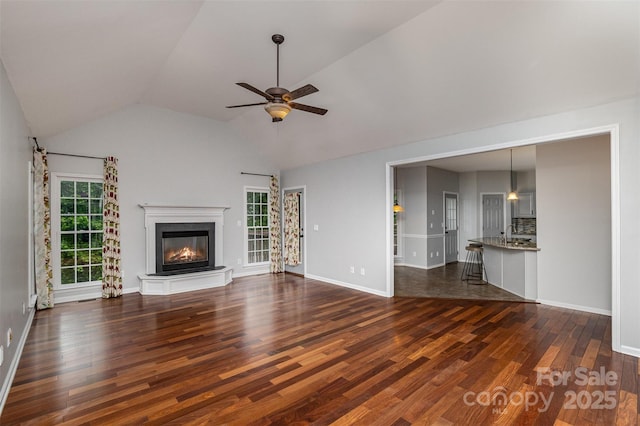17318 Cambridge Grove Dr, Huntersville, NC 28078 - unfurnished living room featuring dark wood finished floors, ceiling fan, a fireplace, vaulted ceiling, and a sink