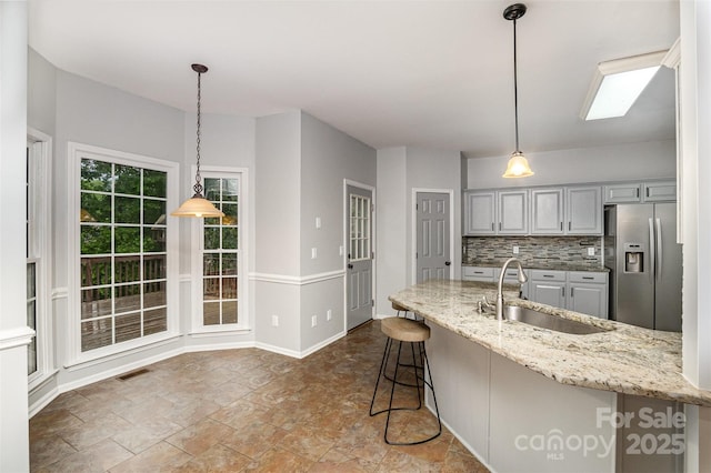 17318 Cambridge Grove Dr, Huntersville, NC 28078 - kitchen with stainless steel fridge, a sink, light stone countertops, backsplash, and pendant lighting