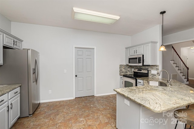 17318 Cambridge Grove Dr, Huntersville, NC 28078 - kitchen with appliances with stainless steel finishes, a sink, a peninsula, light stone finish flooring, and a breakfast bar