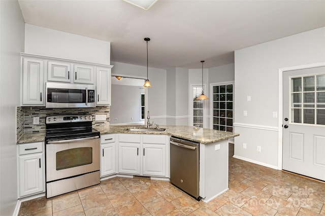17318 Cambridge Grove Dr, Huntersville, NC 28078 - kitchen with stainless steel appliances, a sink, a peninsula, tasteful backsplash, and decorative light fixtures