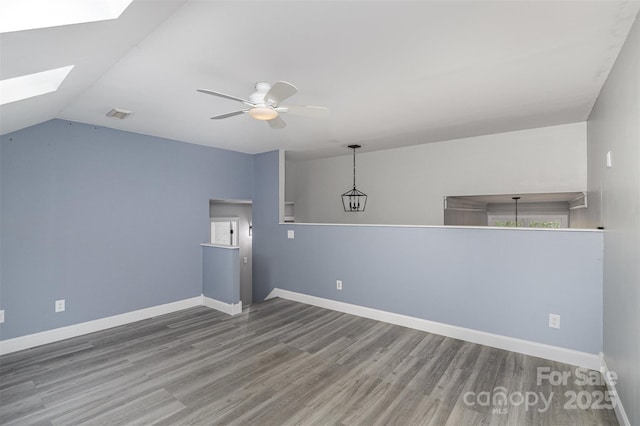 17318 Cambridge Grove Dr, Huntersville, NC 28078 - spare room with a skylight, wood finished floors, ceiling fan, baseboards, and vaulted ceiling