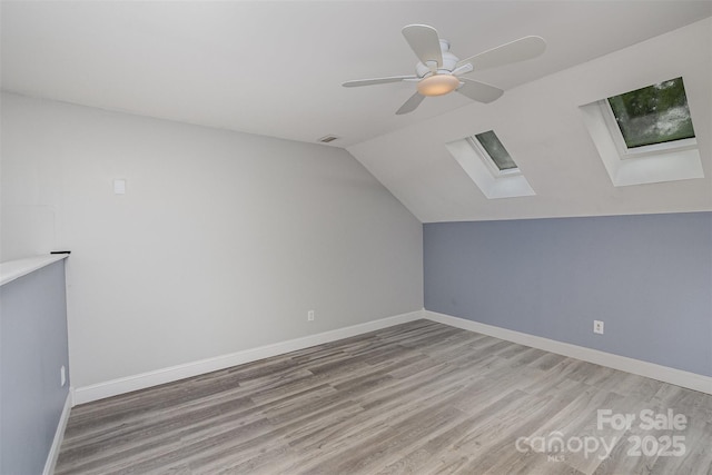 17318 Cambridge Grove Dr, Huntersville, NC 28078 - additional living space featuring a skylight, light wood-type flooring, vaulted ceiling, ceiling fan, and baseboards