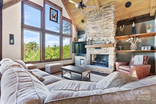 living room featuring wooden ceiling, high vaulted ceiling, a ceiling fan, a fireplace, and beam ceiling