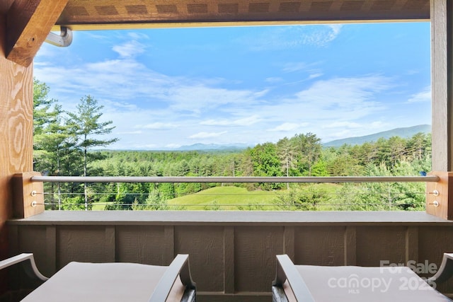 balcony featuring a mountain view and a forest view