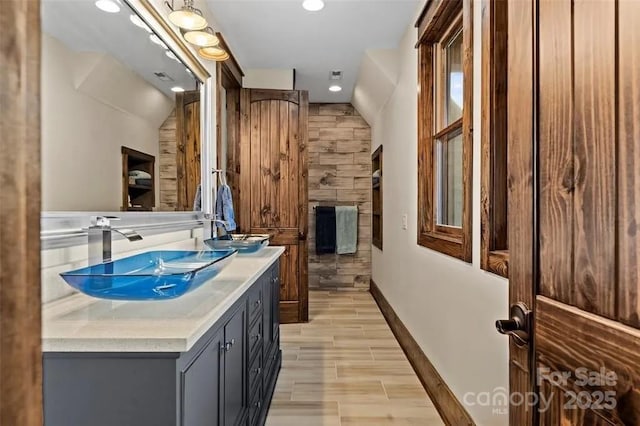 full bathroom with recessed lighting, double vanity, and wood finished floors