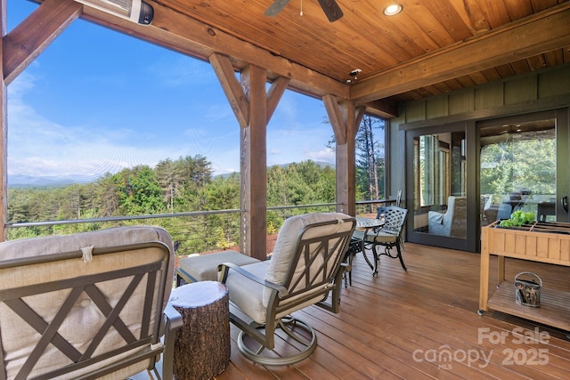 deck featuring a wooded view and ceiling fan