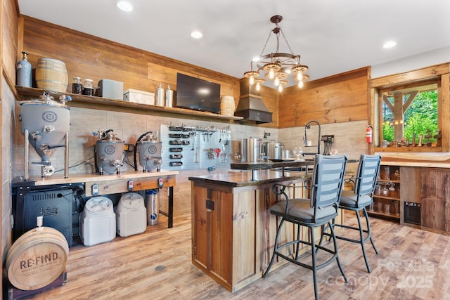 2775 Campbells Trce, Nebo, NC 28761 - kitchen featuring wall chimney range hood, a kitchen bar, light wood-style floors, recessed lighting, and decorative backsplash
