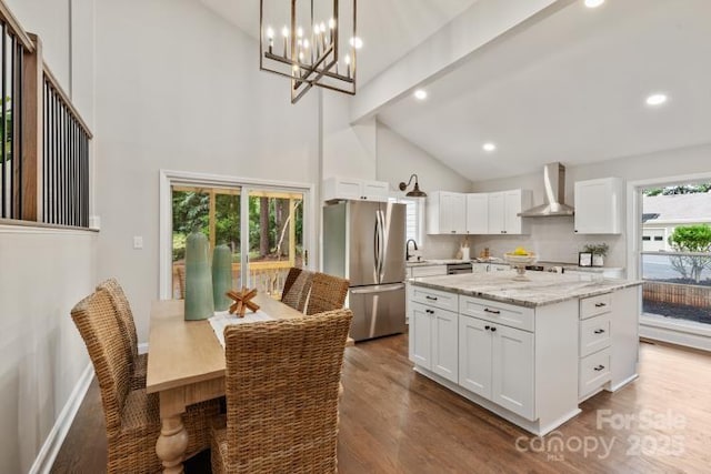 1096 Palmyra Dr, Tega Cay, SC 29708 - kitchen with freestanding refrigerator, wall chimney range hood, dark wood-type flooring, white cabinetry, and high vaulted ceiling
