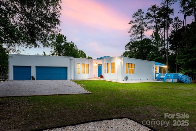 3911 Sandy Point Dr, York, SC 29745 - view of front of house with gravel driveway, a front lawn, an attached garage, stucco siding, and a wooden deck