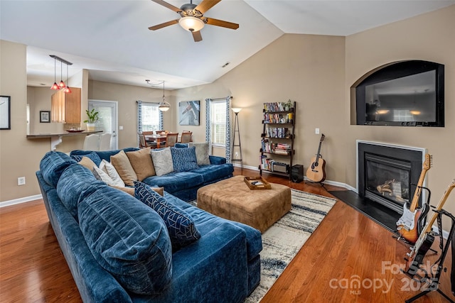 19539 Denae Lynn Dr, Cornelius, NC 28031 - living area with a ceiling fan, wood finished floors, a glass covered fireplace, lofted ceiling, and baseboards