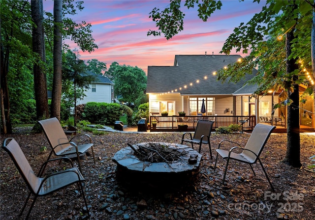 patio terrace at dusk with an outdoor fire pit and a deck