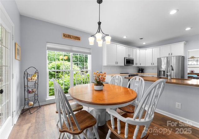 dining area with wood finished floors, recessed lighting, and baseboards