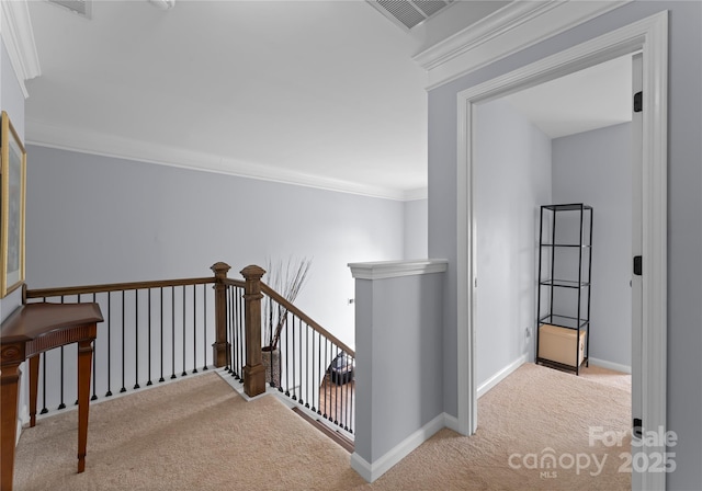 corridor with an upstairs landing, carpet flooring, ornamental molding, and baseboards