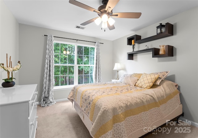 bedroom with light colored carpet, baseboards, and a ceiling fan