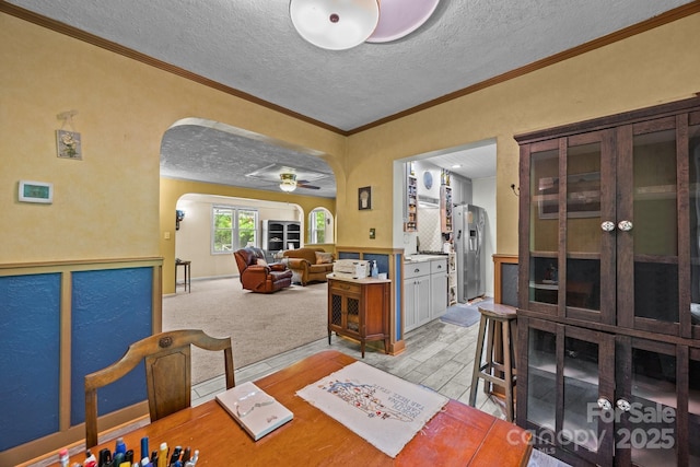 3905 NC Highway 213, Marshall, NC 28753 - dining room featuring arched walkways, a textured ceiling, a ceiling fan, crown molding, and light wood-style floors