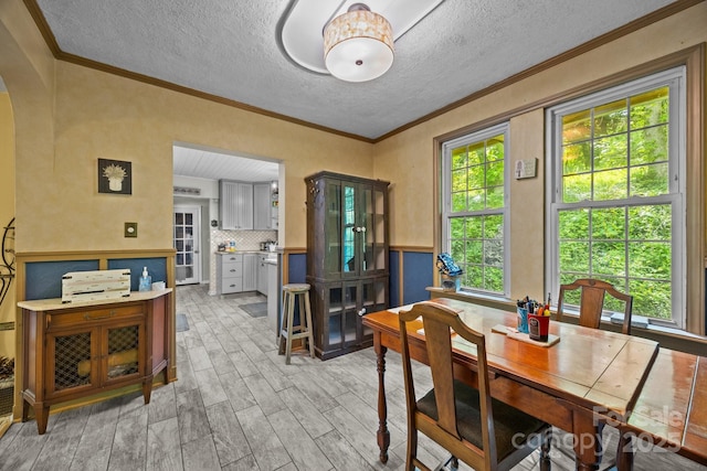 3905 NC Highway 213, Marshall, NC 28753 - dining space with light wood-style floors, a textured ceiling, arched walkways, and crown molding