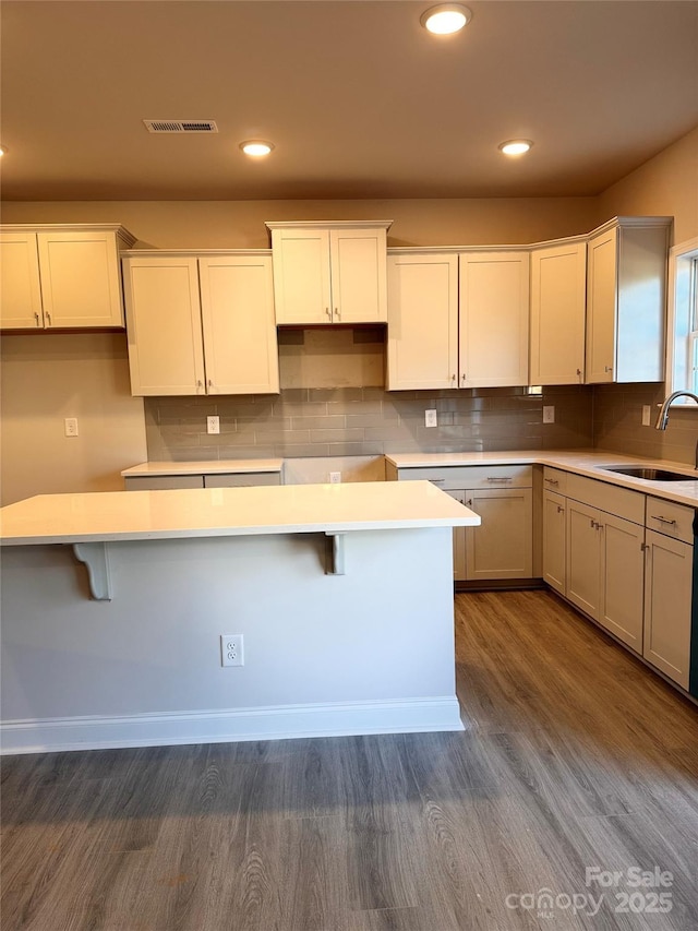 4041 Port Richmond Ave Unit 9, Gastonia, NC 28056 - kitchen featuring a sink, dark wood-style floors, tasteful backsplash, a breakfast bar, and recessed lighting