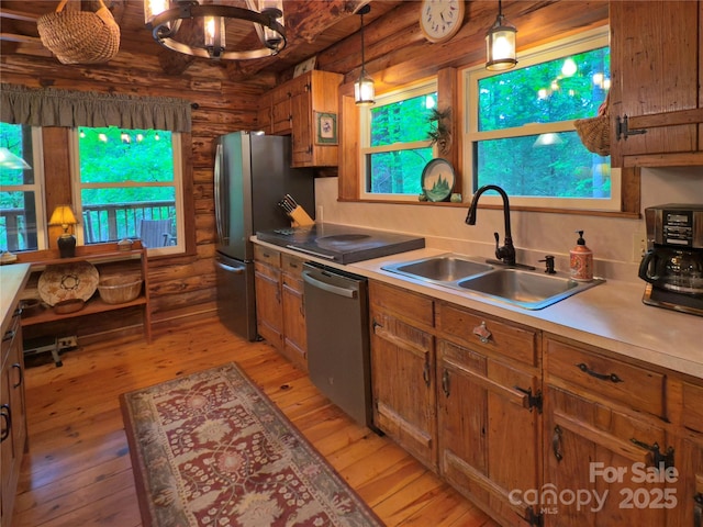 615 Sweetwater Rdg, Burnsville, NC 28714 - kitchen featuring appliances with stainless steel finishes, a sink, light wood-type flooring, log walls, and brown cabinets