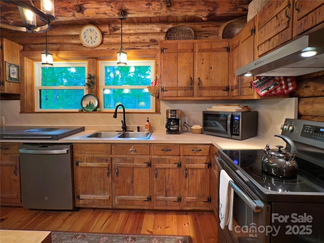 615 Sweetwater Rdg, Burnsville, NC 28714 - kitchen featuring stainless steel appliances, a sink, under cabinet range hood, rustic walls, and light wood-style flooring