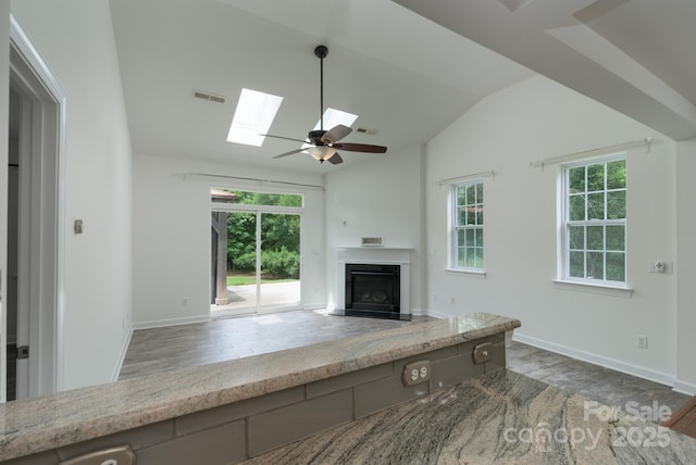 11945 Red Rust Ln, Charlotte, NC 28277 - unfurnished living room featuring wood finished floors, a skylight, a glass covered fireplace, vaulted ceiling, and a ceiling fan