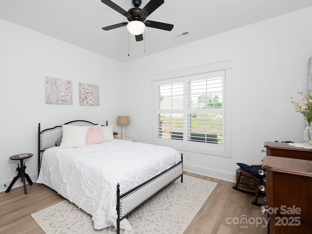 bedroom featuring wood finished floors, baseboards, and ceiling fan
