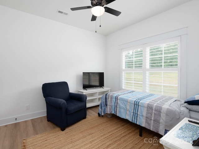 bedroom with wood finished floors, baseboards, and ceiling fan