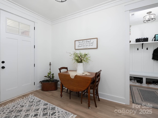 dining space with wood finished floors, baseboards, and ornamental molding